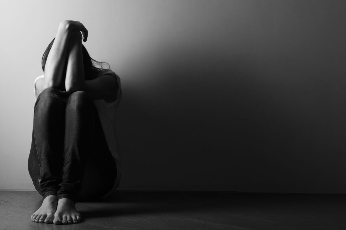 Joven aislado en una habitación representando el impacto emocional de las conductas de riesgo en la adolescencia
