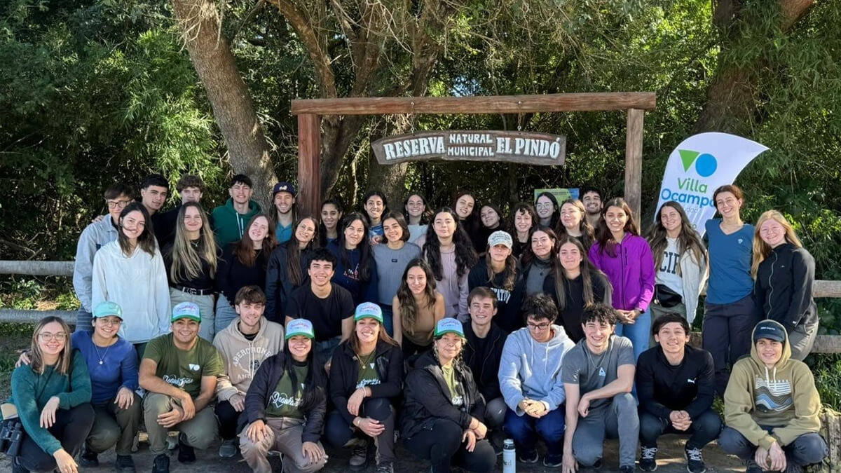 Grupo de estudiantes universitarios de Ingeniería Ambiental en la entrada de la Reserva Natural Municipal El Pindó en Villa Ocampo