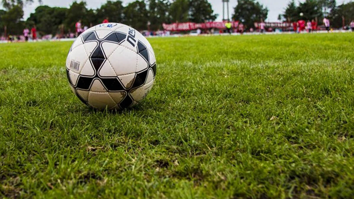 Pelota de fútbol sobre el campo de juego en partido de la Liga Reconquistense
