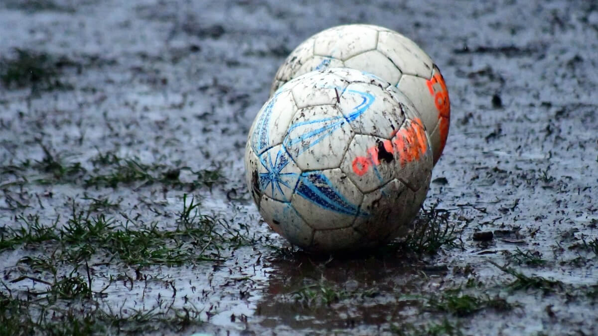 pelota en campo de juego con agua acumulada por la lluvia 