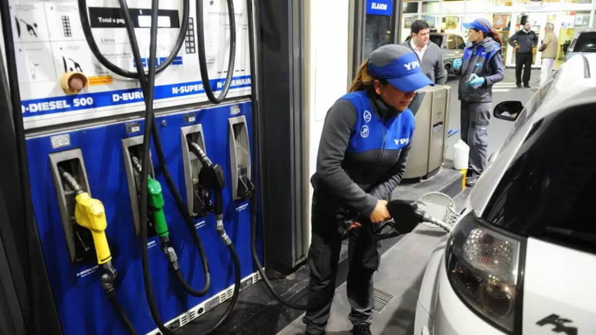 Operador de estación de servicio cargando nafta en vehículo bajo el nuevo sistema de monitoreo de YPF.