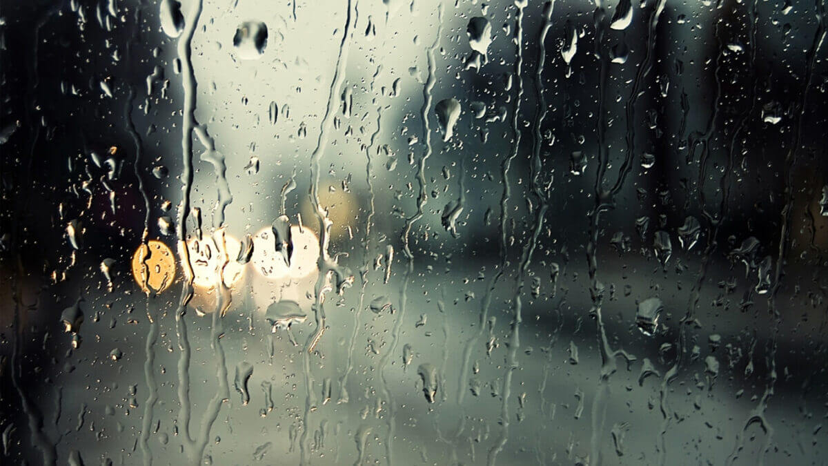 Un primer plano de un vidrio con gotas de lluvia escurriendo