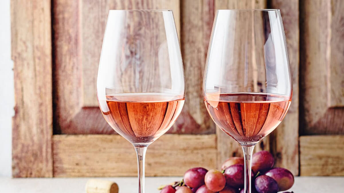 Dos copas de vino rosado servidas sobre una mesa, simbolizando el creciente consumo en Argentina.