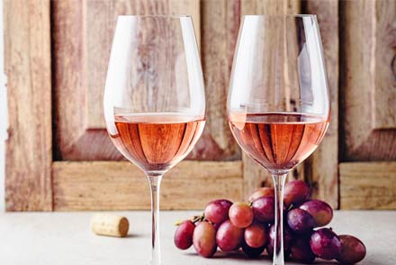 Dos copas de vino rosado servidas sobre una mesa, simbolizando el creciente consumo en Argentina.