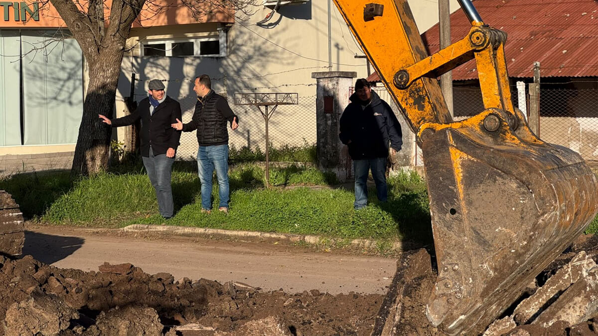 Obras de repavimentación en calle Alberdi de Villa Ocampo, con maquinaria vial y operarios trabajando.