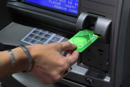 Persona retirando dinero en un cajero automático durante el cronograma de pagos provinciales