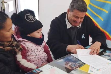 Presidente comunal Roberto Giuliani firmando uno de los boletos de compraventa de los terrenos