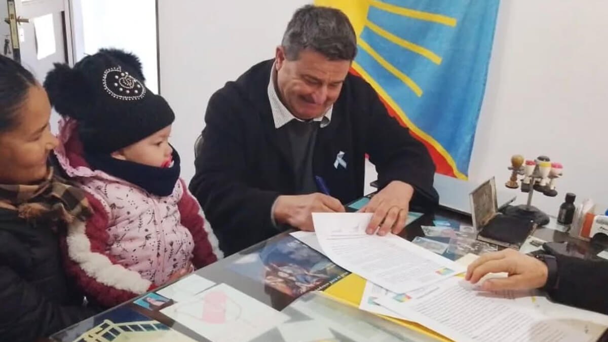Presidente comunal Roberto Giuliani firmando uno de los boletos de compraventa de los terrenos