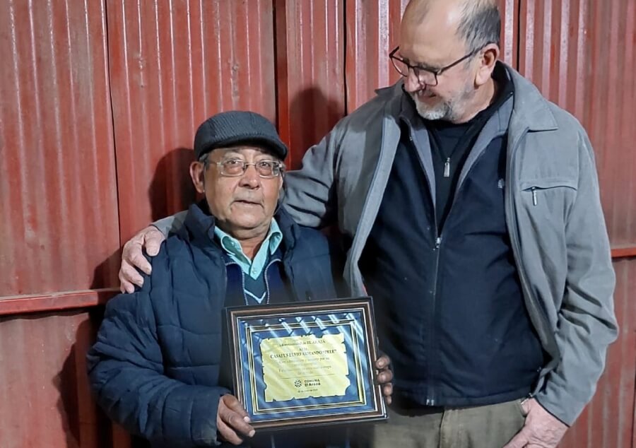 Presidente comunal Edgardo Cainelli entregando una plaqueta a Elvio Casafus por su paso por la institución comunal