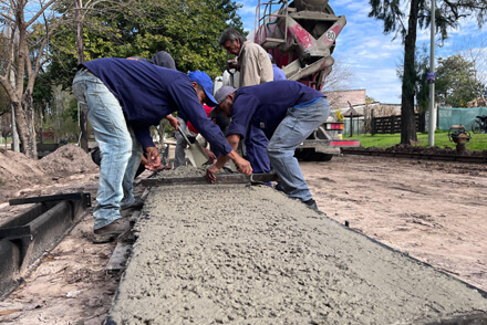 Empleados municipales realizando trabajos de hormigonado del cordón cuneta en calle Musulin