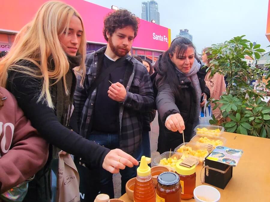 Promoción de productos de Malabrigo en la Expo Rural de Palermo 2025, con visitantes degustando naranjas, miel y quesos artesanales del norte santafesino.