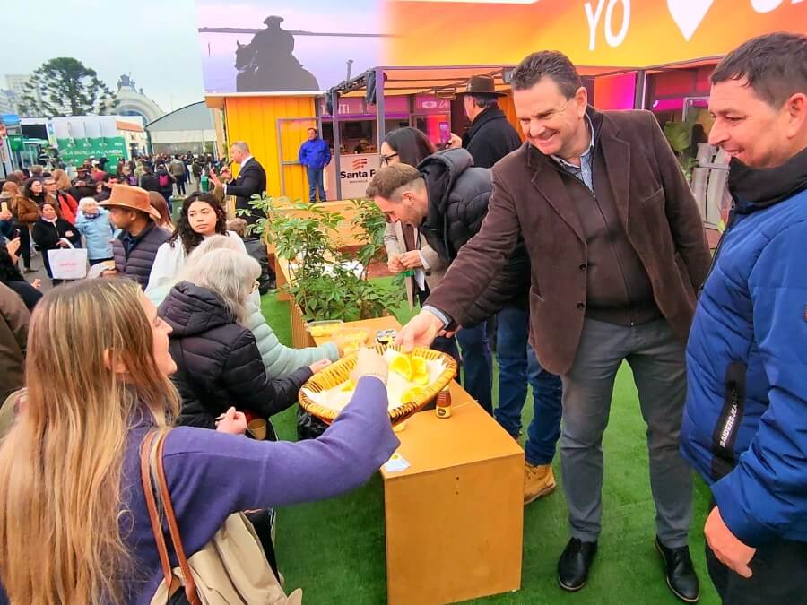 Promoción de productos de Malabrigo en la Expo Rural de Palermo 2025, con visitantes degustando naranjas, miel y quesos artesanales del norte santafesino.