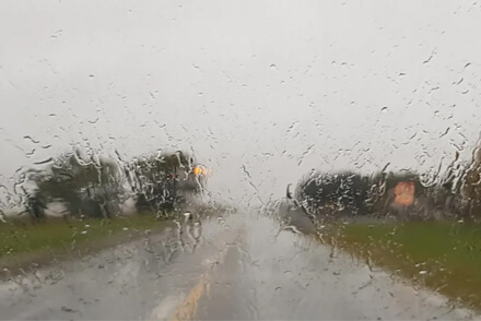 Día lluvioso visto a través del vidrio de un auto con gotas de lluvia