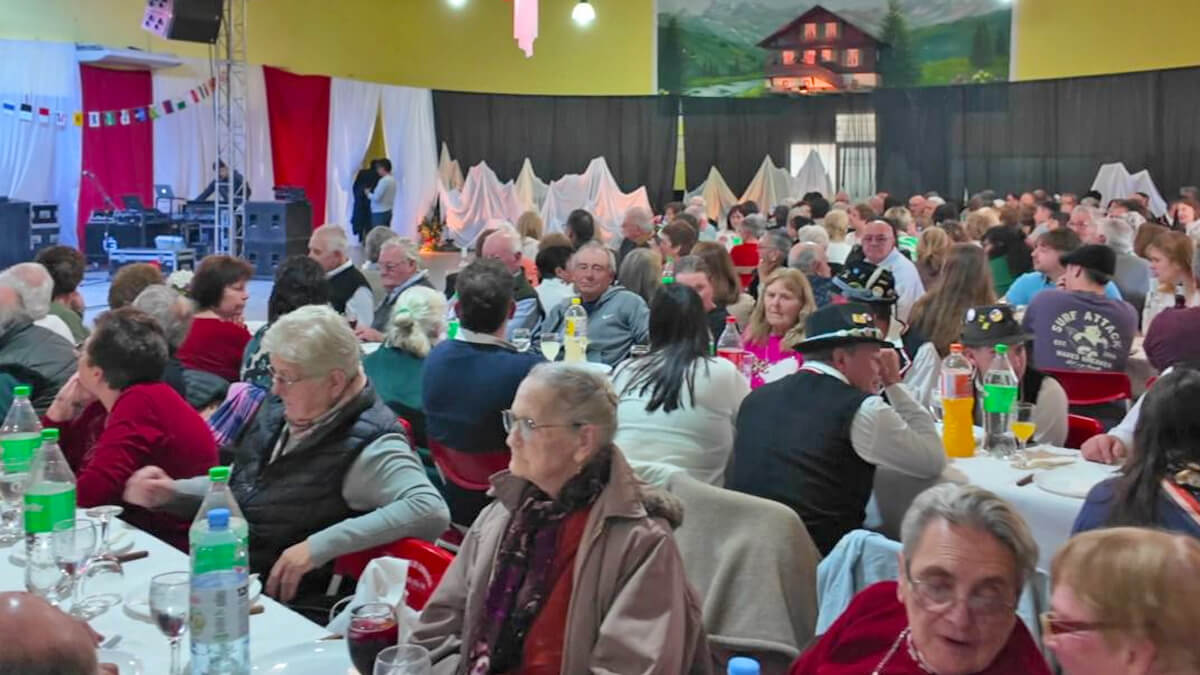 Salón de la Fiesta Provincial Suiza en Romang con asistentes disfrutando del tradicional almuerzo típico.