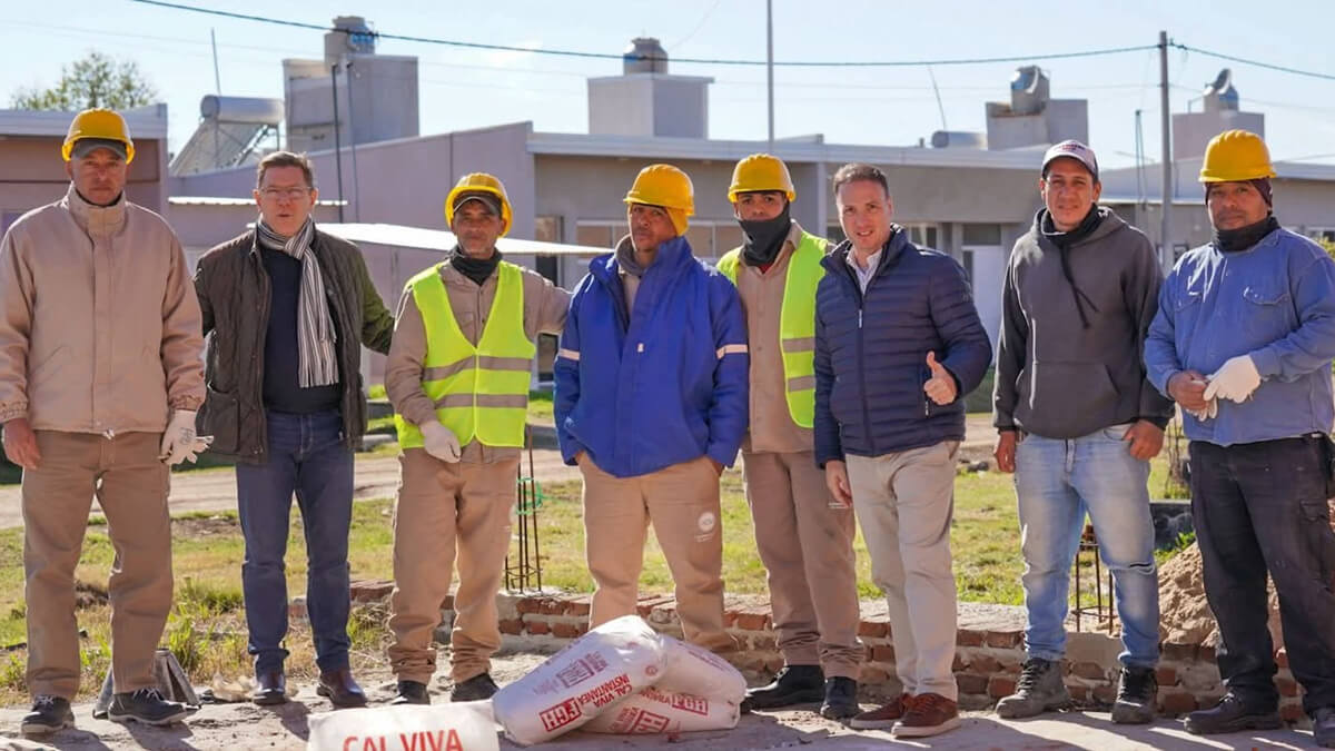 El senador Rodrigo Borla y el ministro Lisandro Enrico junto a trabajadores en la obra de construcción de viviendas en San Justo.