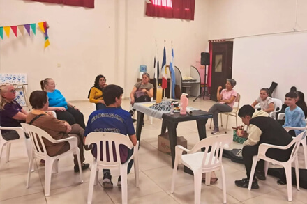 Encuentro entre adultos mayores y jóvenes del Taller Comunal de Guitarra en Las Garzas, compartiendo música y sonrisas.