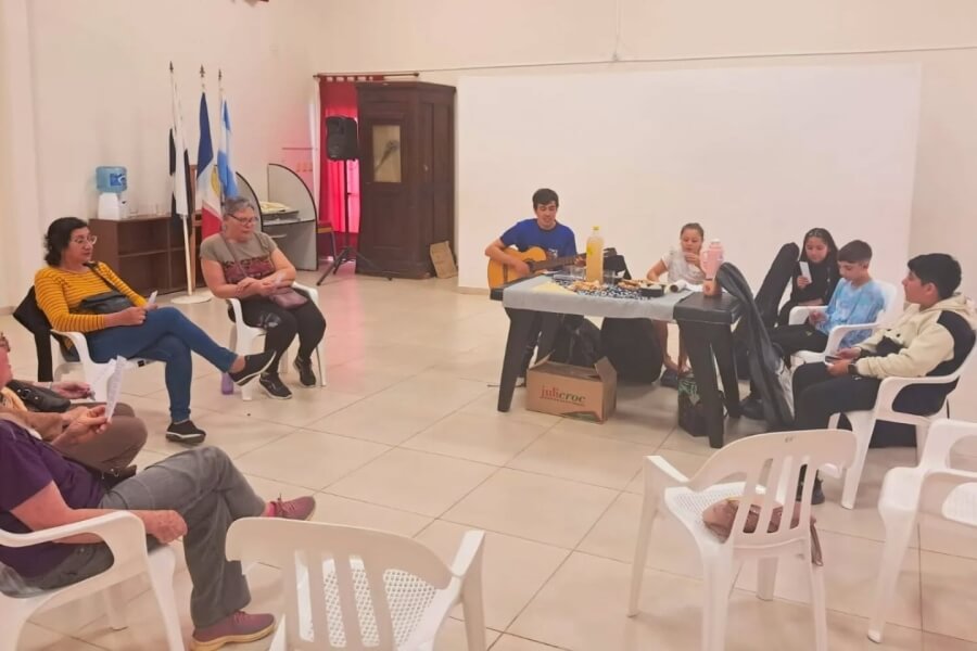 Encuentro entre adultos mayores y jóvenes del Taller Comunal de Guitarra en Las Garzas, compartiendo música y sonrisas.