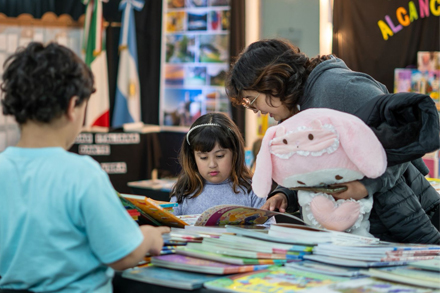 Niños con sus padres visitando la Feria del Libro de Vera.