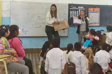 Carolina Gómez y Eve Ravelli frente a los alumnos de la Escuela N°562 durante la jornada de higiene en Cacique Ariacaiquín.