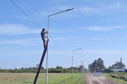 Operarios municipales reponiendo cables del alumbrado público en calle Storni de Villa Ocampo