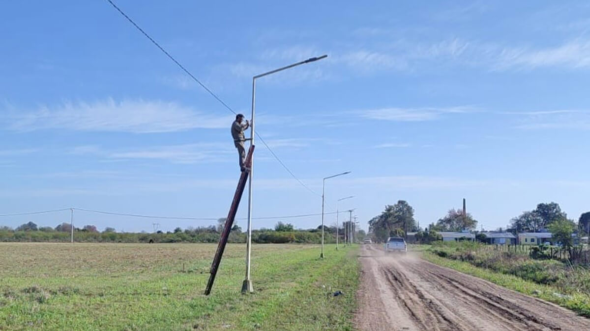 Operarios municipales reponiendo cables del alumbrado público en calle Storni de Villa Ocampo