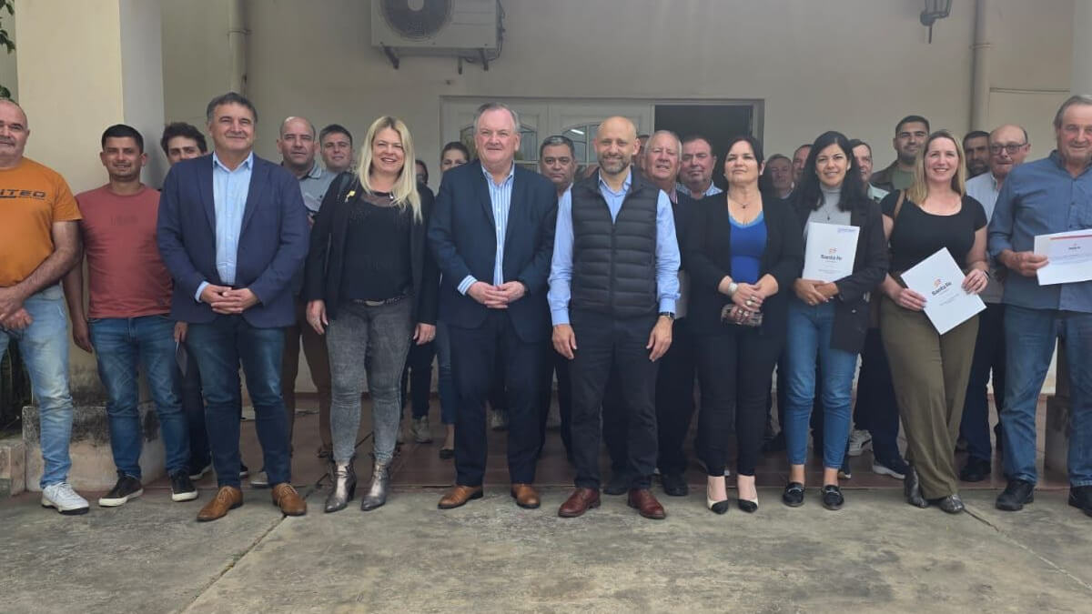 El senador Felipe Michlig y el ministro Gustavo Puccini junto a beneficiarios durante la entrega de créditos en San Cristóbal