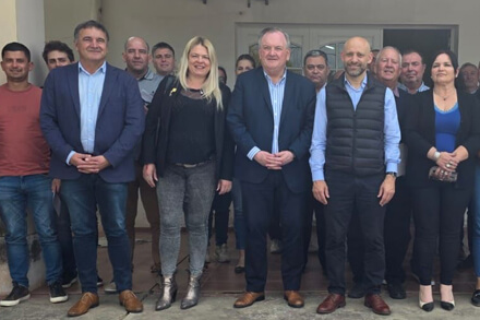 El senador Felipe Michlig y el ministro Gustavo Puccini junto a beneficiarios durante la entrega de créditos en San Cristóbal