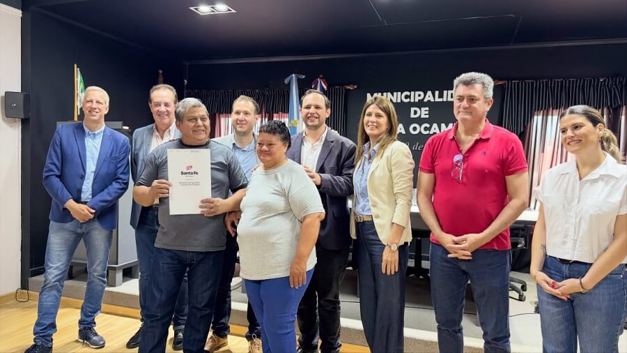 Familia beneficiaria del provincial de Regularización Dominial recibiendo su título de propiedad