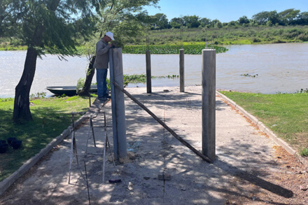 Obras de construcción del muelle en el Paseo Costanero de Romang con maquinaria y operarios trabajando en la costa santafesina