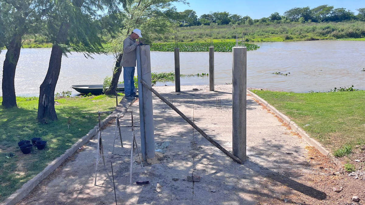 Obras de construcción del muelle en el Paseo Costanero de Romang con maquinaria y operarios trabajando en la costa santafesina