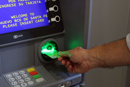 Empleado público cobrando sueldo en cajero automático en Santa Fe con aumento del 5% en haberes de octubre