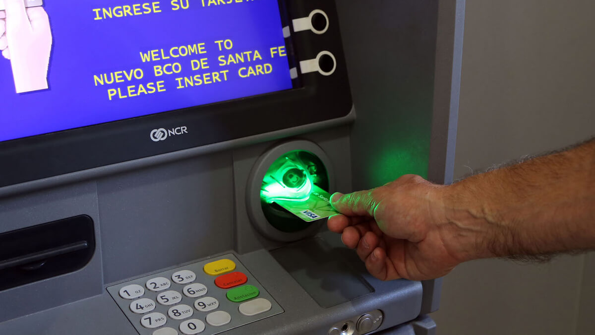 Empleado público cobrando sueldo en cajero automático en Santa Fe con aumento del 5% en haberes de octubre