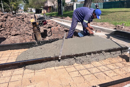 Operarios municipales construyen cordón cuneta en calle Brigadier López, Romang, obra de infraestructura urbana con contribución de vecinos