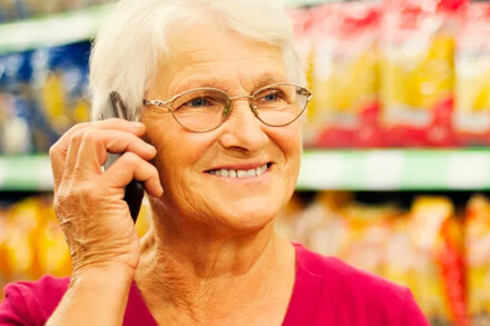 Jubilada contenta haciendo compras en supermercado SuperCoop Romang con descuento del 10%