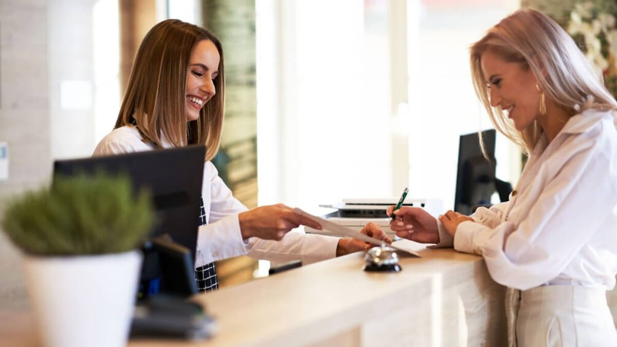 Personal hotelero realizando check-in de pasajero