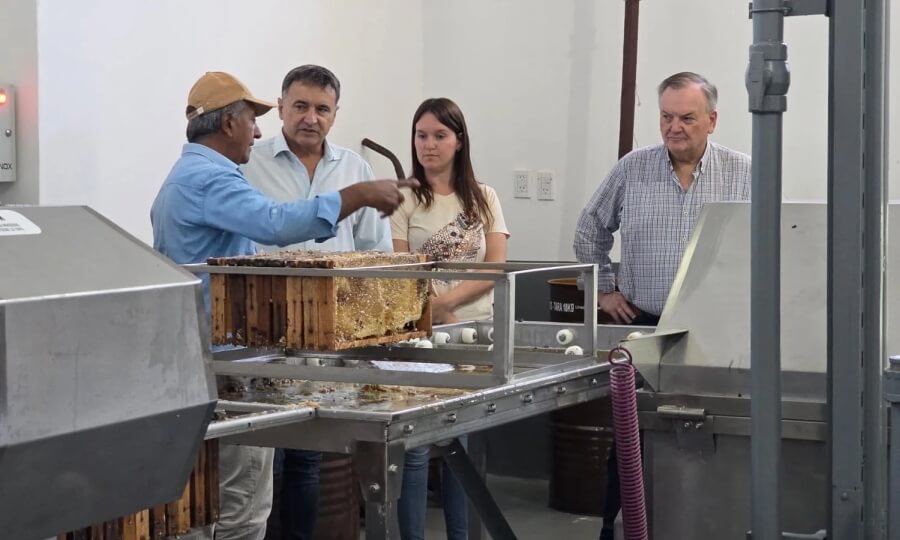Senador Michlig y autoridades recorriendo la planta apícola mientras un integrante de la cooperativa explica el proceso de extracción de miel