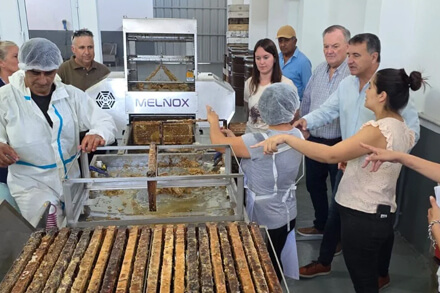 Senador Felipe Michlig recorriendo la sala de extracción de miel en Ambrosetti junto a autoridades, cooperativa de apicultores, producción apícola
