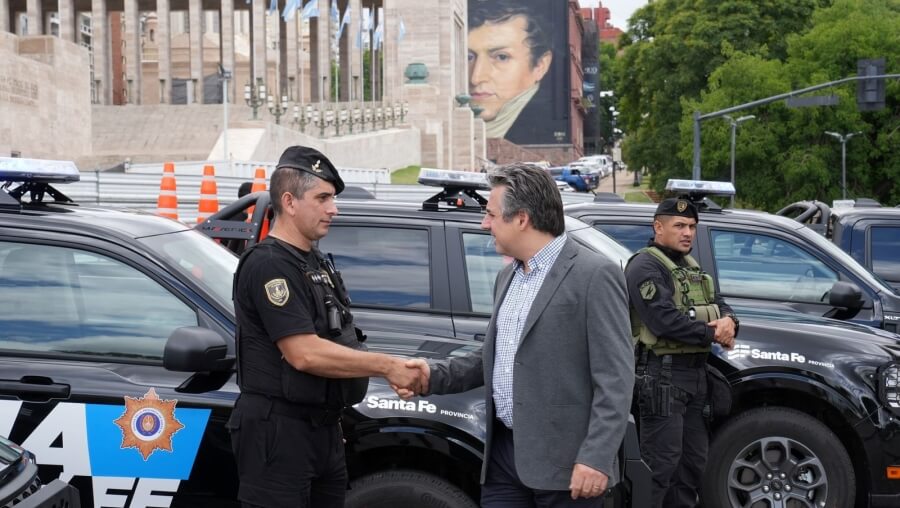 Ministro Pablo Cococcioni saluda a miembros de la fuerza de seguridad provincial en el acto de entrega de patrulleros frente al Monumento a la Bandera