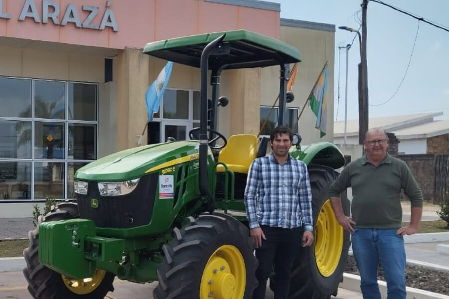 l presidente comunal Alfredo Cainelli, junto a un operario, posando al lado del nuevo tractor incorporado al parque de maquinarias de la Comuna.