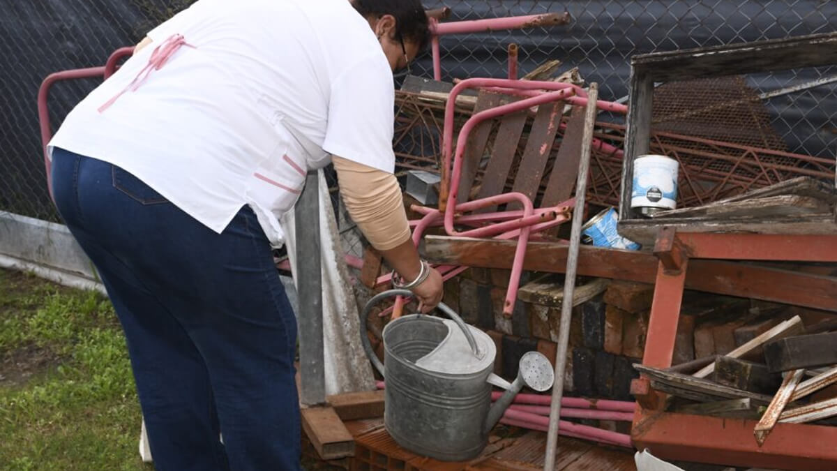 Agente municipal de Avellaneda revisan patio de vivienda en operativo contra el dengue, inspeccionando recipientes y conversando con vecinos para prevenir criaderos de mosquito Aedes aegypti