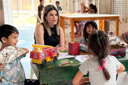 Diputada Charo Mancini interactuando con niños durante su visita a la Fundación San Miguel Arcángel en Las Toscas.