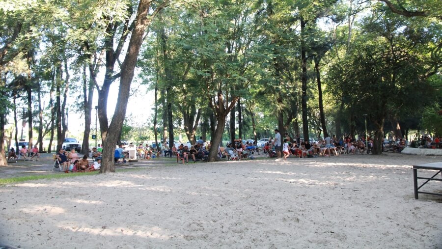 Familias disfrutando del verano bajo la frondosa arboleda del Camping Municipal Los Tatané en Avellaneda