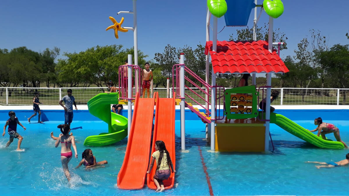 Chicos disfrutando de la pileta y juegos acuáticos en el Camping Municipal Los Tatané de Avellaneda durante el verano