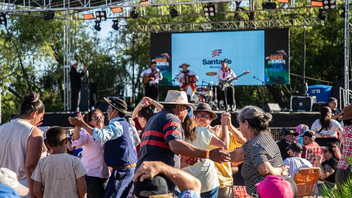 Gente bailando frente al escenario con banda de chamamé en la Fiesta Regional de la Arena Blanca en Malabrigo