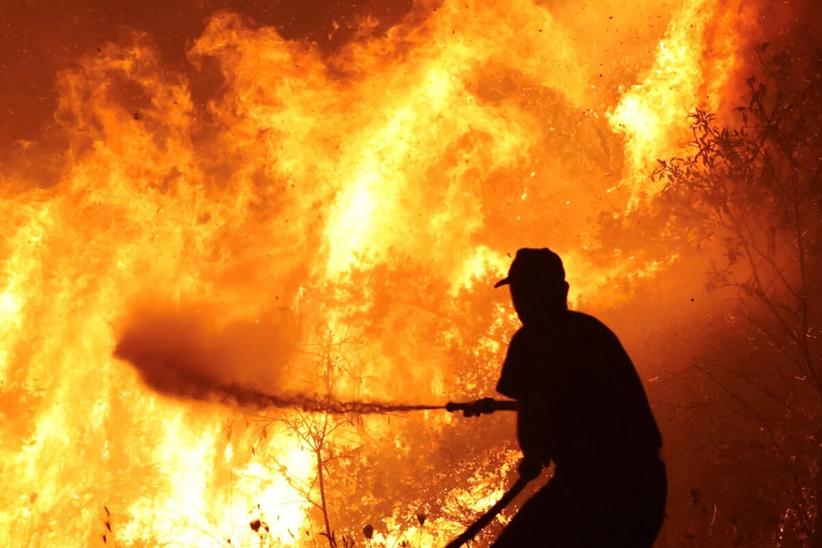 Bombero voluntario combatiendo incendio de pastizales en Villa Ocampo durante temporada de altas temperaturas