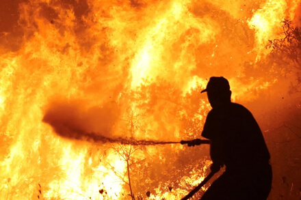 Bombero voluntario combatiendo incendio de pastizales en Villa Ocampo durante temporada de altas temperaturas