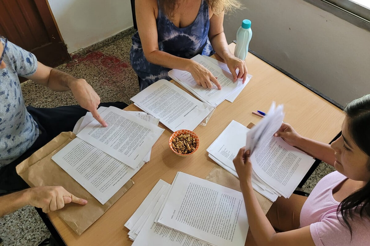 Escritoras del jurado trabajando en la revisión de trabajos en concurso literario anterior, simbolizando el proceso de selección de cuentos y poemas.