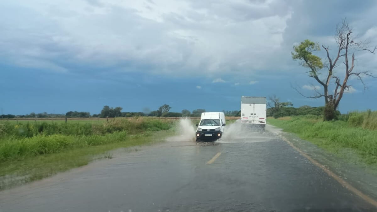 Ruta Nacional 11 entre Nelson y Llambi Campbell con gran acumulación de agua tras intensas lluvias y vehículos circulando con precaución
