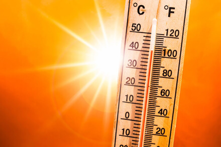 Termómetro marcando temperatura extrema con sol intenso de fondo