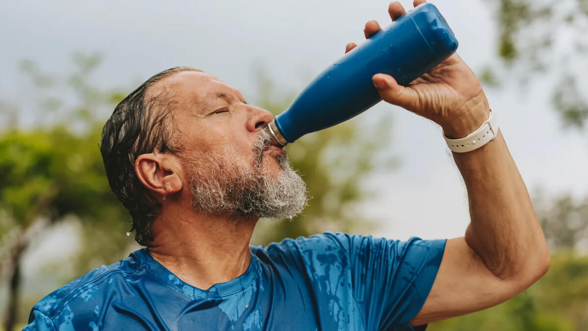 Persona bebiendo agua para hidratarse durante ola de calor, altas temperaturas, cuidado salud